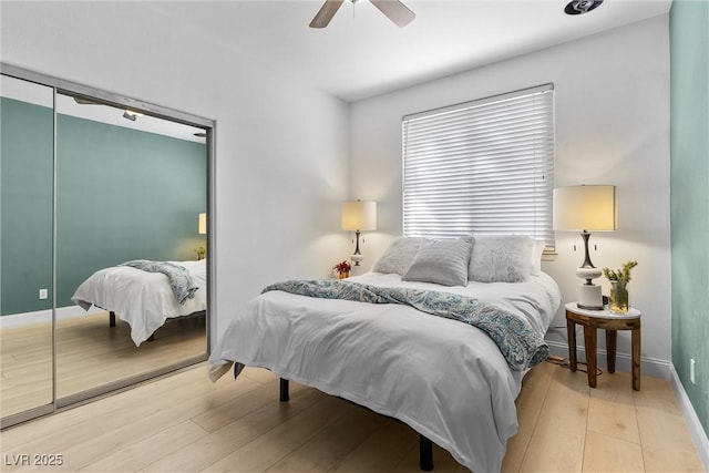 bedroom with baseboards, light wood-style floors, and a ceiling fan