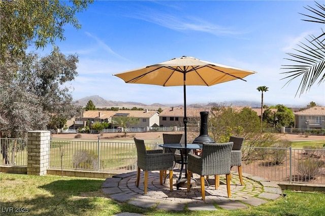 view of patio / terrace featuring a mountain view, fence, and a residential view