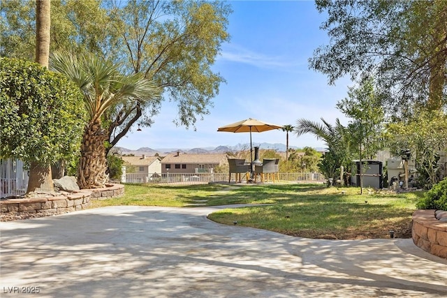 view of property's community featuring a yard, a patio, and fence