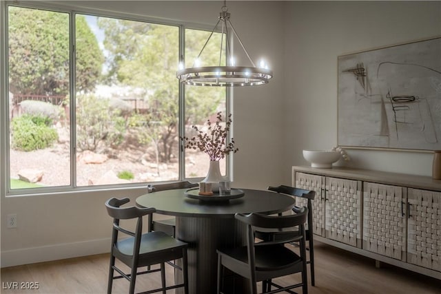dining space with plenty of natural light, wood finished floors, and baseboards