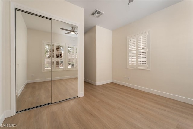 unfurnished bedroom with wood finished floors, baseboards, a closet, and a ceiling fan