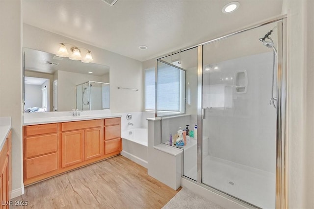 8919 Don Valley Ave, Las Vegas, NV 89148 - bathroom with vanity, a garden tub, visible vents, wood finished floors, and a stall shower