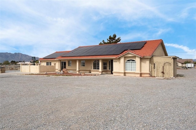 1800 Red Rock Dr, Pahrump, NV 89048 - view of front facade with a tile roof, fence, covered porch, and stucco siding