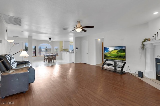 1800 Red Rock Dr, Pahrump, NV 89048 - living room featuring visible vents, a ceiling fan, wood finished floors, and a fireplace with flush hearth
