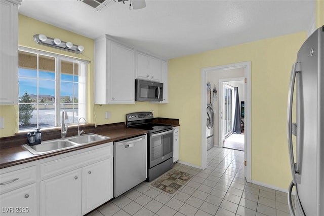1800 Red Rock Dr, Pahrump, NV 89048 - kitchen featuring light tile patterned floors, white cabinetry, dark countertops, appliances with stainless steel finishes, and a sink