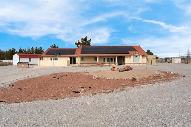 1800 Red Rock Dr, Pahrump, NV 89048 - view of front of home with a porch, stucco siding, and roof mounted solar panels