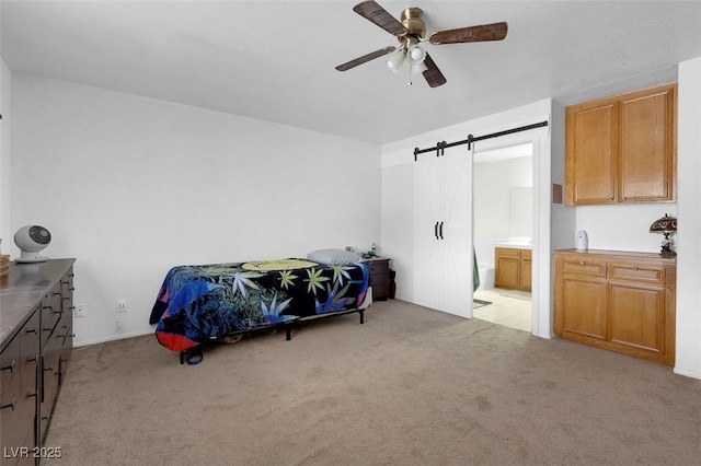 1800 Red Rock Dr, Pahrump, NV 89048 - bedroom featuring a ceiling fan, connected bathroom, a barn door, and light carpet