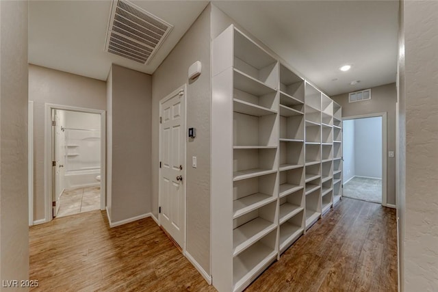hallway featuring wood finished floors and baseboards