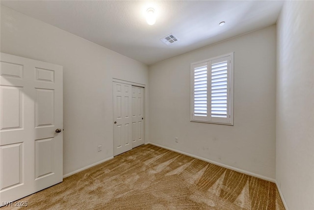 unfurnished bedroom featuring carpet floors, baseboards, and a closet