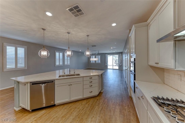 kitchen featuring plenty of natural light, visible vents, a sink, open floor plan, and appliances with stainless steel finishes