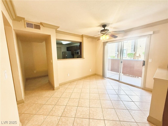 empty room with crown molding, ceiling fan, baseboards, light tile patterned floors, and visible vents