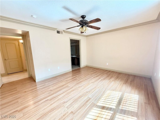 spare room featuring crown molding, a ceiling fan, baseboards, light wood-type flooring, and visible vents