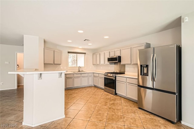 7829 Lovely Pine Pl, Las Vegas, NV 89143 - kitchen with a peninsula, a breakfast bar, light countertops, a sink, and stainless steel appliances