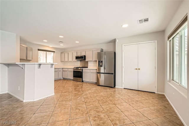 7829 Lovely Pine Pl, Las Vegas, NV 89143 - kitchen featuring visible vents, plenty of natural light, light countertops, appliances with stainless steel finishes, and a breakfast bar