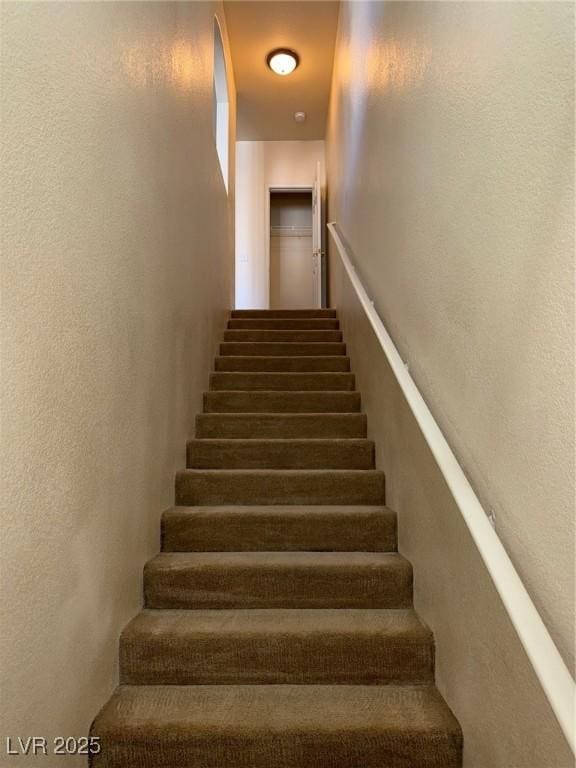 stairway featuring a textured wall