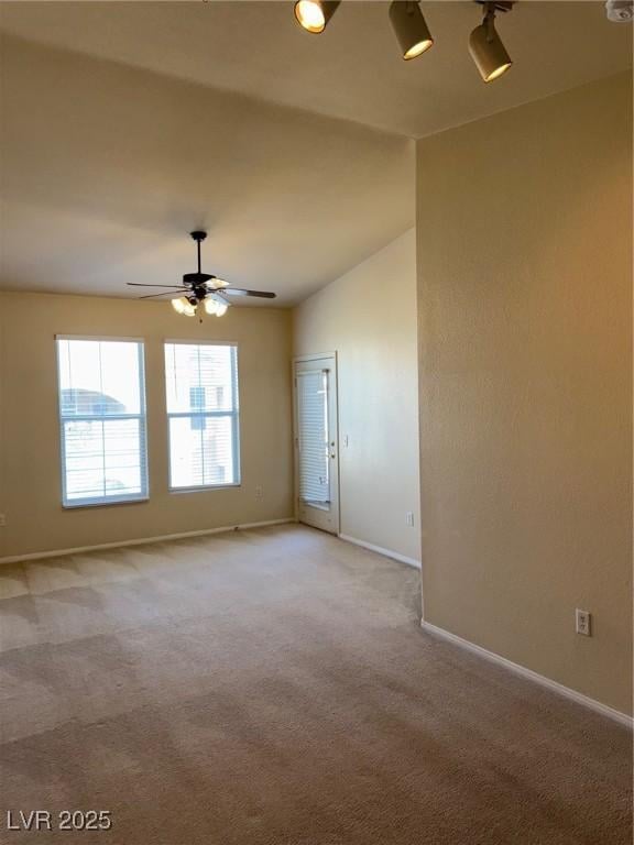 empty room featuring light colored carpet, ceiling fan, and baseboards