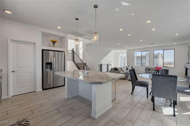 7953 Mountain Lilac St, Las Vegas, NV 89113 - kitchen with wood finish floors, recessed lighting, a center island, stainless steel fridge, and hanging light fixtures
