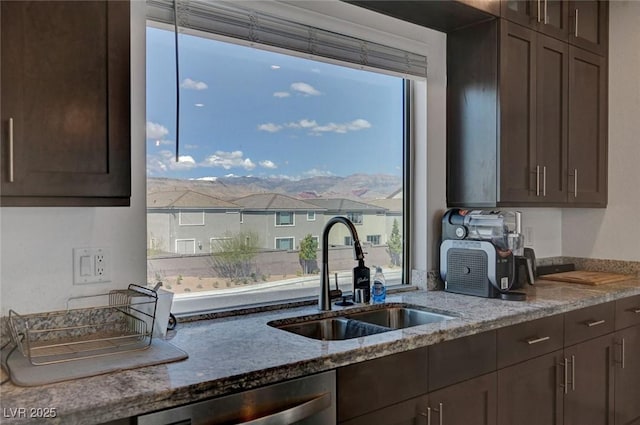 7953 Mountain Lilac St, Las Vegas, NV 89113 - kitchen with light stone countertops, dark brown cabinetry, dishwasher, a sink, and a residential view
