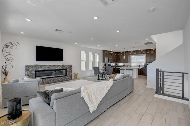 7953 Mountain Lilac St, Las Vegas, NV 89113 - living room featuring a glass covered fireplace, recessed lighting, and visible vents