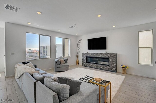 7953 Mountain Lilac St, Las Vegas, NV 89113 - living room with visible vents, baseboards, light wood-type flooring, recessed lighting, and a glass covered fireplace