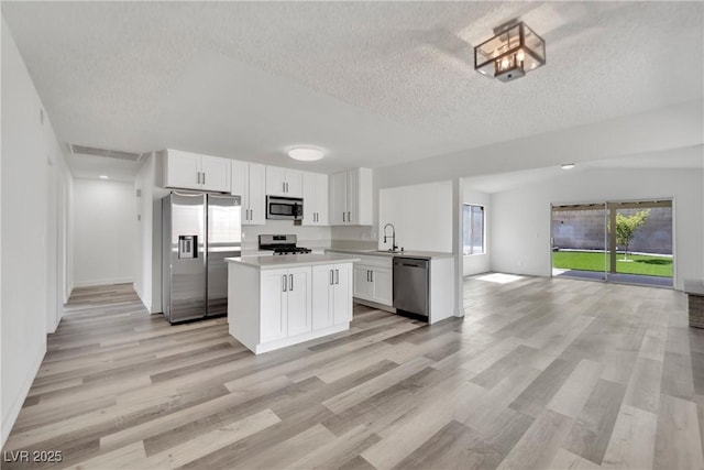 4623 Kearney St, Las Vegas, NV 89147 - kitchen with stainless steel appliances, open floor plan, a textured ceiling, light countertops, and a sink