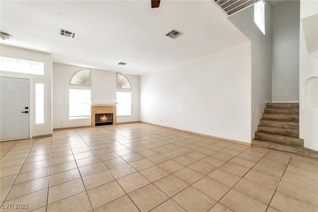 121 Golf Course St, Las Vegas, NV 89145 - unfurnished living room with baseboards, light tile patterned floors, a tiled fireplace, and visible vents