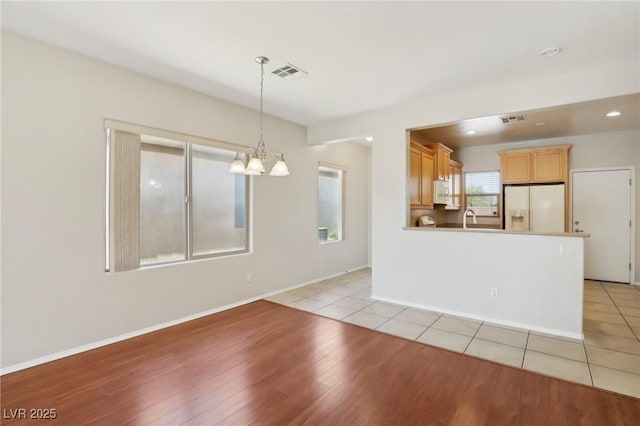 6059 Wheat Penny Ave, Las Vegas, NV 89122 - empty room with visible vents, baseboards, an inviting chandelier, and light wood-style floors
