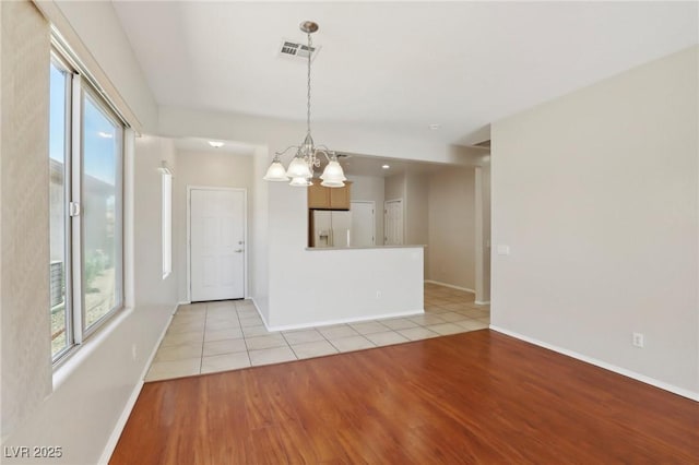 6059 Wheat Penny Ave, Las Vegas, NV 89122 - spare room with visible vents, baseboards, an inviting chandelier, and light wood-style floors