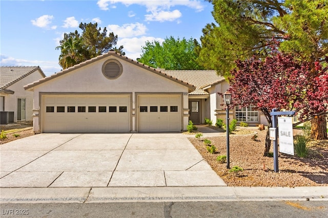 view of front of home with stucco siding, central air condition unit, driveway, an attached garage, and a tile roof