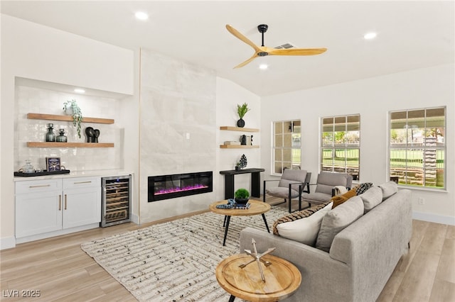 living room with light wood-style floors, ceiling fan, bar, and wine cooler