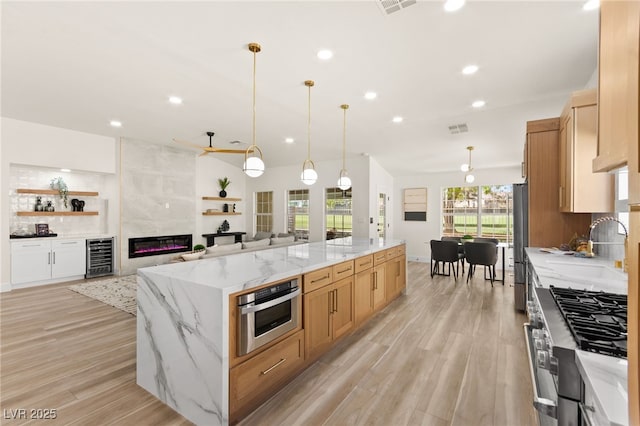 kitchen with a large island, appliances with stainless steel finishes, a sink, beverage cooler, and decorative backsplash
