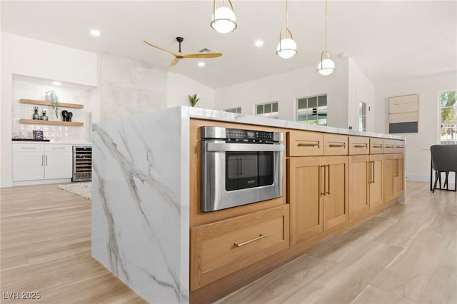 kitchen featuring light wood-style flooring, open shelves, a ceiling fan, beverage cooler, and oven