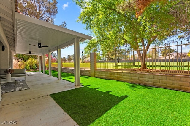 view of yard with a patio, fence, and ceiling fan