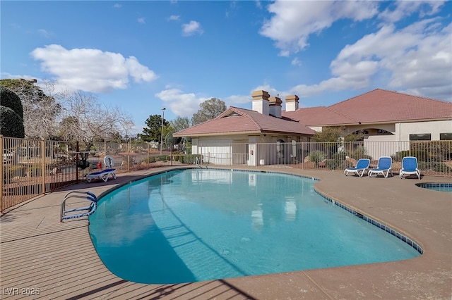 community pool featuring a patio area and fence