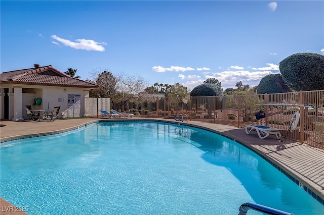 community pool featuring a patio and fence