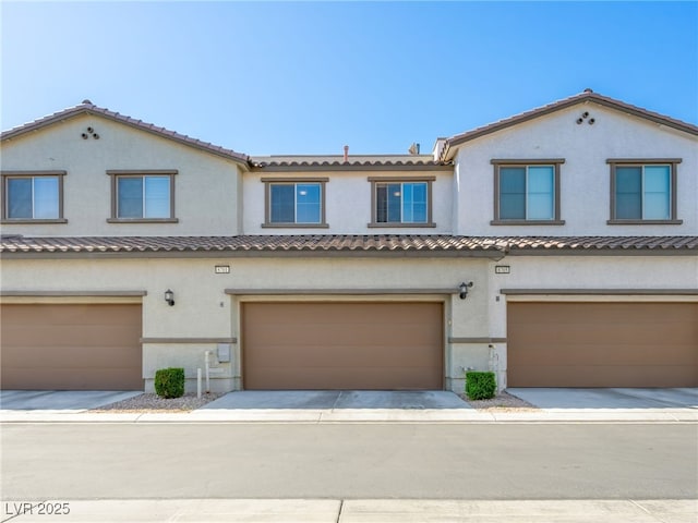 multi unit property featuring an attached garage, stucco siding, and a tile roof