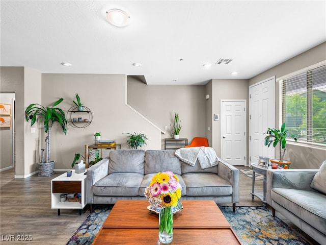 living area with recessed lighting, visible vents, baseboards, and wood finished floors