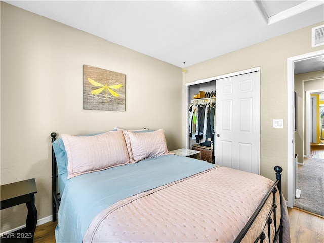 bedroom with a closet, baseboards, and wood finished floors