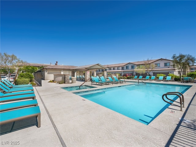 community pool featuring a patio area, fence, and a community hot tub