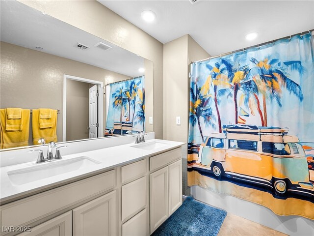 bathroom featuring double vanity, visible vents, and a sink