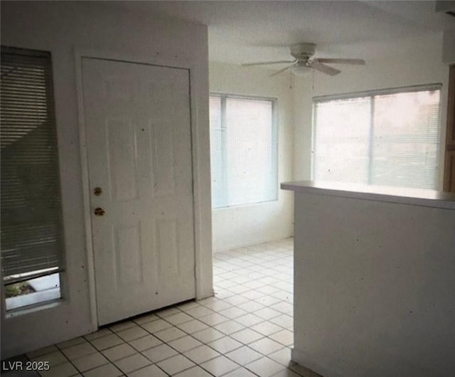 foyer entrance with light tile patterned floors and a ceiling fan