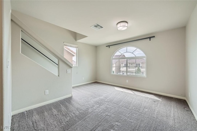 unfurnished room with baseboards, carpet, and visible vents