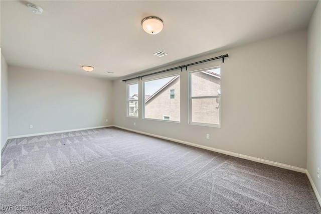 carpeted empty room featuring baseboards and visible vents
