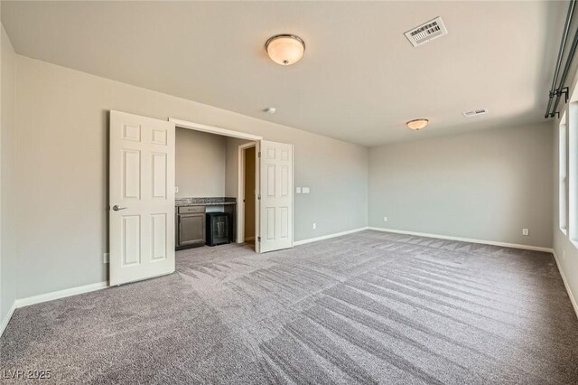 unfurnished room featuring visible vents, baseboards, and light carpet