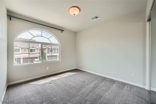 unfurnished room featuring baseboards, visible vents, and carpet floors