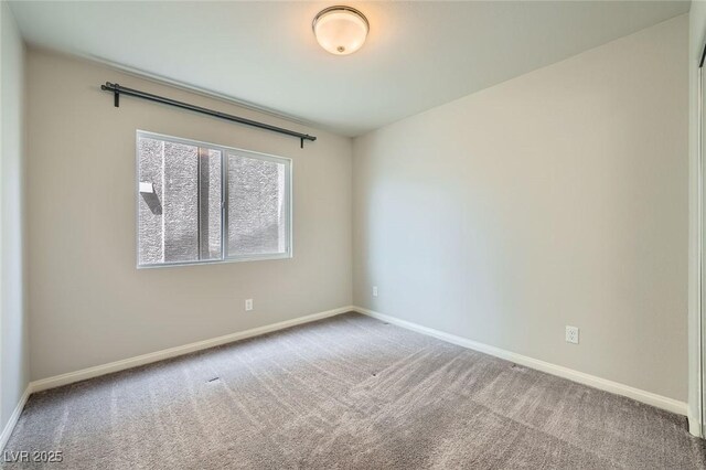 carpeted empty room featuring baseboards