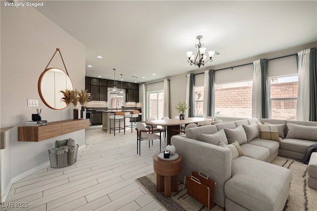 living area featuring recessed lighting, an inviting chandelier, and light wood-style floors