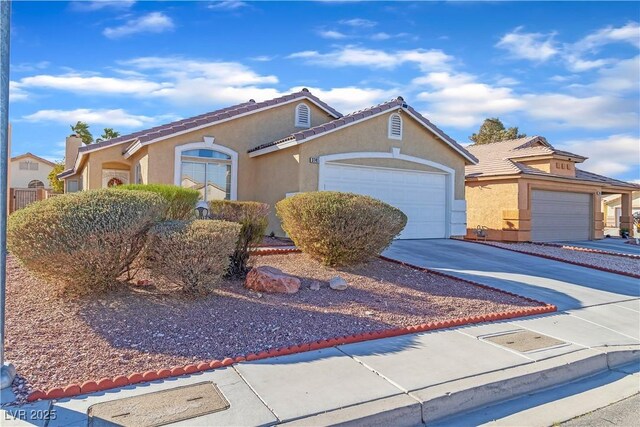view of front of property featuring driveway, a garage, stucco siding, and a tiled roof
