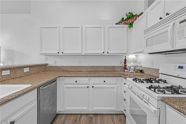 kitchen featuring light stone counters, wood finished floors, white cabinetry, and white appliances