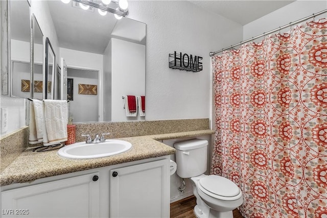 bathroom with curtained shower, wood finished floors, toilet, and vanity